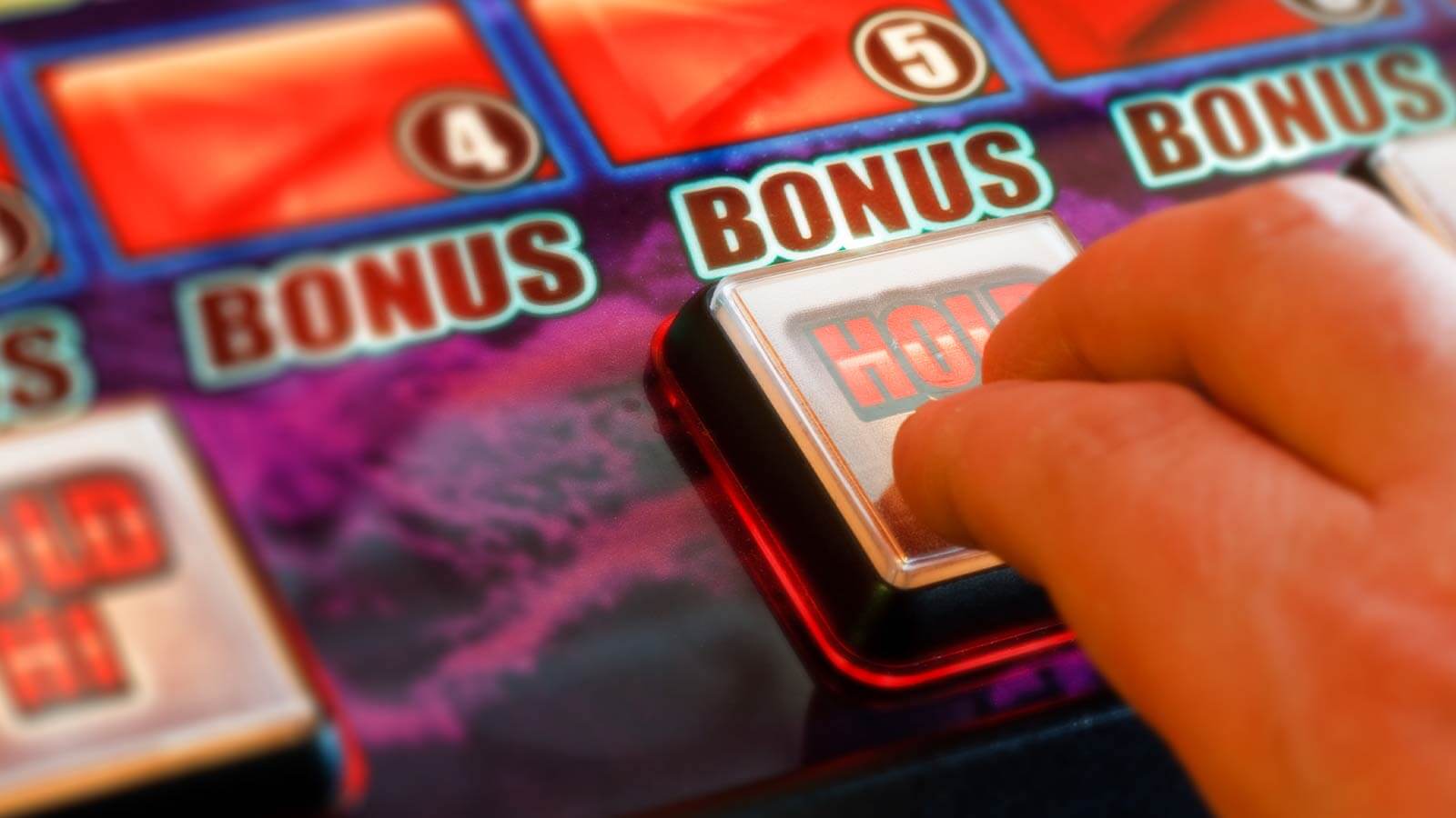 une main appuyant sur un bouton bonus sur une machine à sous