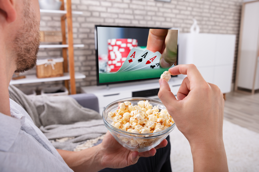 Un spectateur, se régalant de popcorn, assiste à une scène trépidante de casino sur grand écran