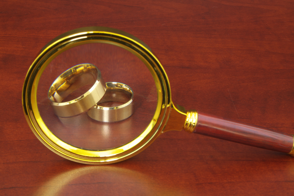 A magnifying glass reflects wedding rings