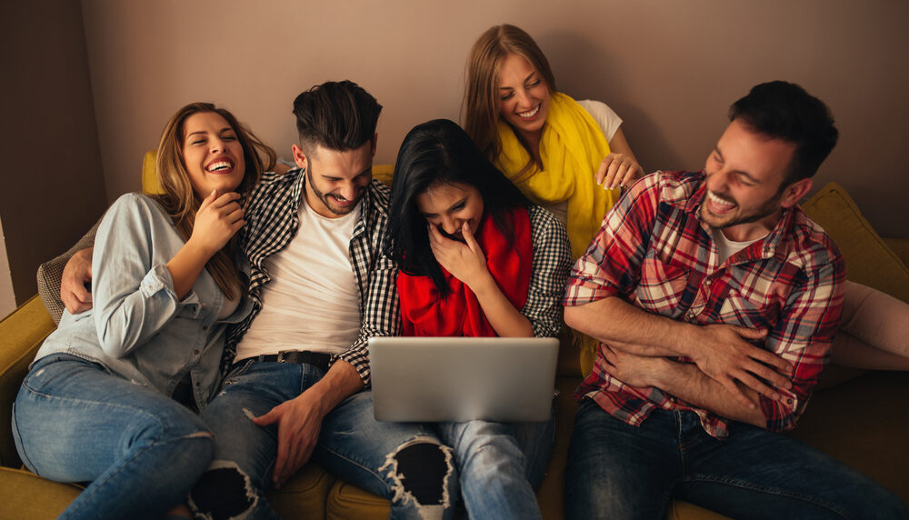 Friends chuckling over a laptop discussion